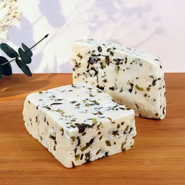 Ahşap masa üzerinde sunulmuş iki büyük dilim Van otlu peyniri, doğal ve katkısız yöresel peynir görünümü